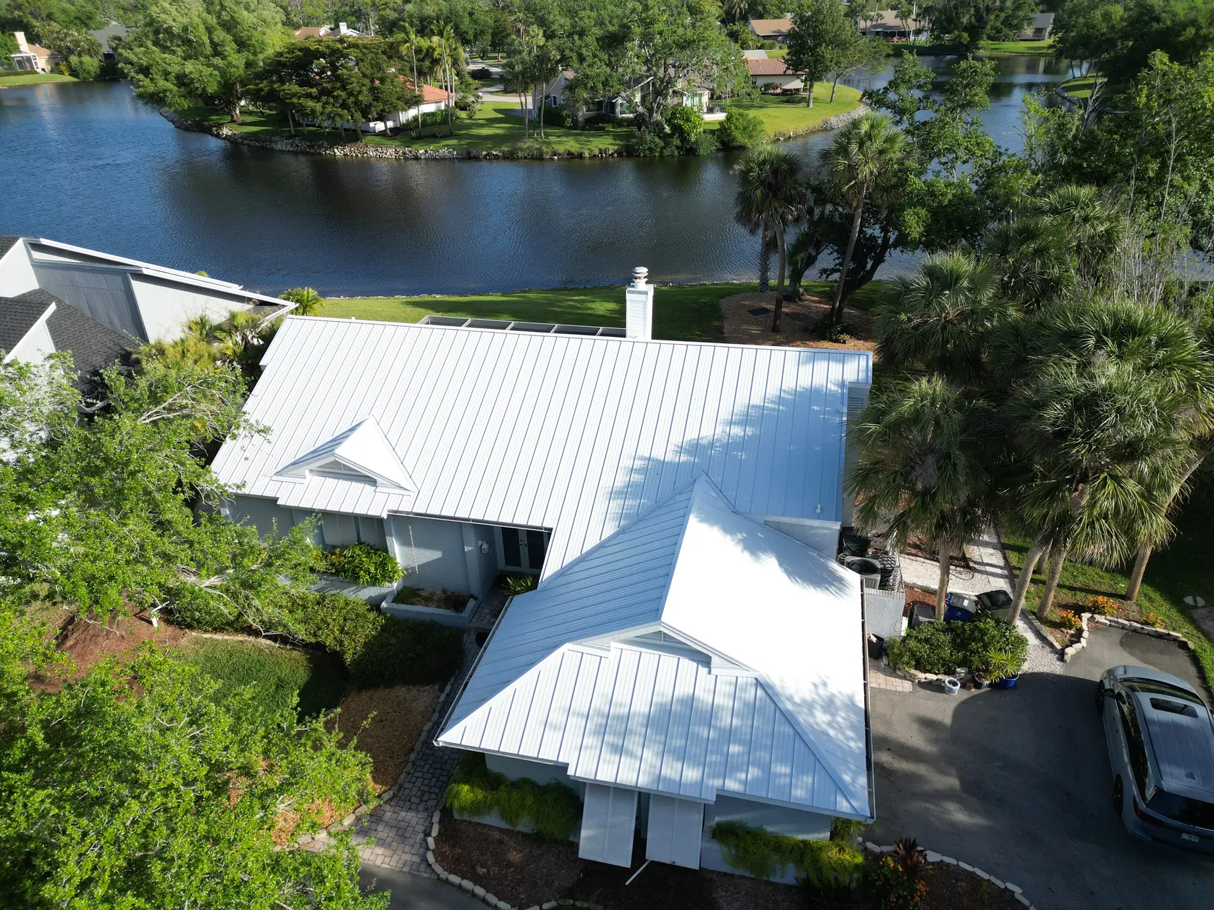 White standing-seam metal roof on a waterfront Cape Coral home