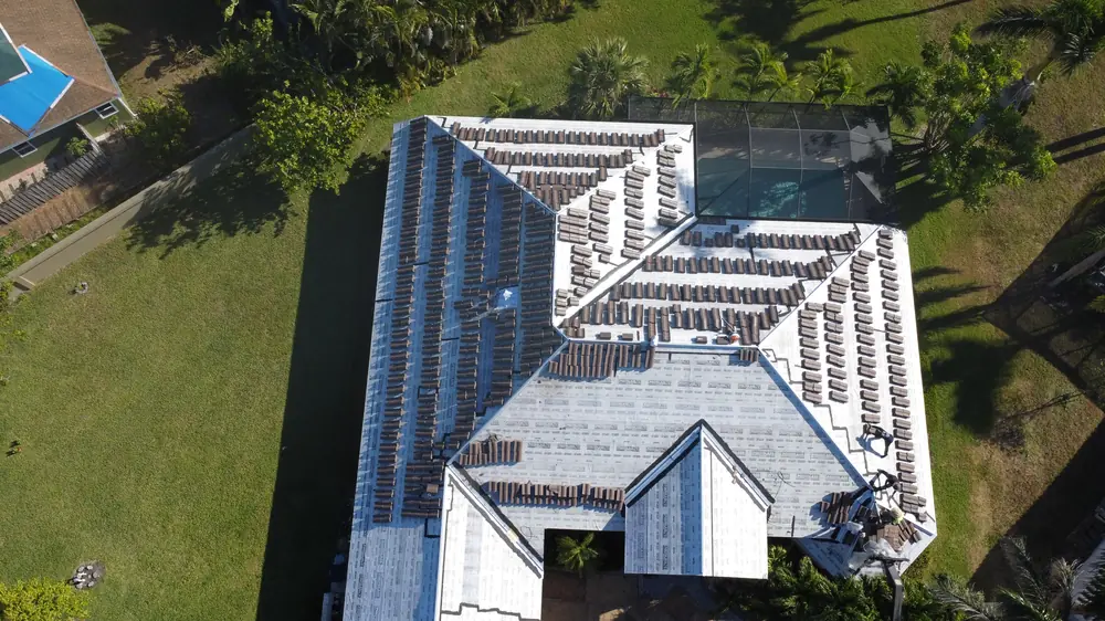 Top-down drone view of a new white flat tile roof on a Fort Myers home