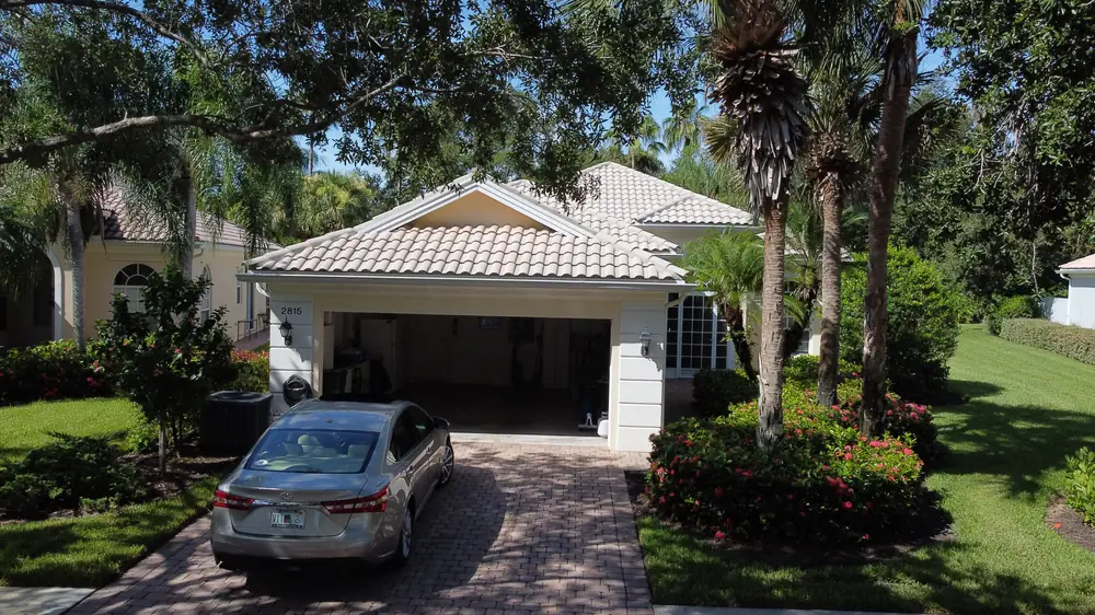 Naples home with a new tan barrel tile roof and paver driveway